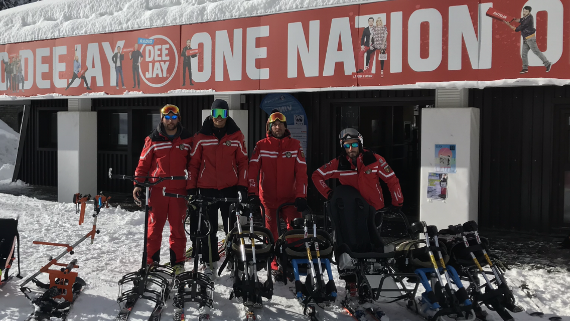 Maestri di sci con gli ausili per le persone con disabilità