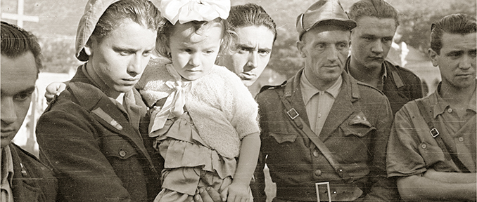 Châtillon (Champ-de-Cort), giugno 1945. Esumazione della salma del capo della banda della Suelvaz Émile Lexert “Milò” dal vecchio cimitero. Al centro il partigiano Mario Minuzzo “Alpino” con in braccio la figlia di Milò Renata Lexert. © Regione autonoma Valle d'Aosta - Foto Octave Bérard (fondo Bérard)